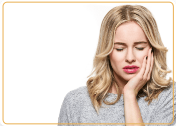 woman holding her cheek in pain